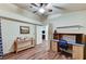 Spacious bedroom featuring wood floors, a ceiling fan, and a built-in desk and workstation at 2035 E Warm Springs Rd # 1019, Las Vegas, NV 89119