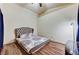 Bedroom with a ceiling fan, wood-look floors and a large bed with decorative pillows at 2035 E Warm Springs Rd # 1019, Las Vegas, NV 89119