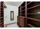 Walk-in closet with dark wood built-in shelving, drawers, and hanging rods at 2035 E Warm Springs Rd # 1019, Las Vegas, NV 89119