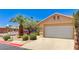 Home exterior featuring a two car garage door, desert landscaping, and palm tree at 2035 E Warm Springs Rd # 1019, Las Vegas, NV 89119
