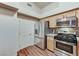 Functional kitchen featuring stainless steel appliances, granite countertops, and wood flooring, with a convenient door to the side at 2035 E Warm Springs Rd # 1019, Las Vegas, NV 89119