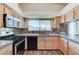 Bright kitchen features stainless steel appliances, wood cabinets, dark countertops and a large window at 2035 E Warm Springs Rd # 1019, Las Vegas, NV 89119