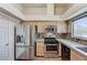 Well-equipped kitchen featuring stainless steel appliances, granite countertops, mosaic backsplash, and wood flooring at 2035 E Warm Springs Rd # 1019, Las Vegas, NV 89119