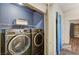 Laundry room featuring newer, front-load washer and dryer units, and overhead shelving at 2035 E Warm Springs Rd # 1019, Las Vegas, NV 89119