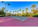 A community tennis court surrounded by lush landscaping and palm trees at 2050 W Warm Springs Rd # 4021, Henderson, NV 89014