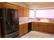 Updated kitchen with stainless steel refrigerator and white countertops and wooden cabinets at 2201 E Dandelion St, Pahrump, NV 89048