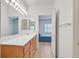 Bright bathroom with a vanity, a large mirror, and an open doorway to the bedroom at 2548 Leighton Ave, Henderson, NV 89052