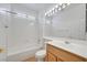 Well-lit bathroom featuring a shower-tub combo, vanity with a wooden finish, and bright lighting at 2548 Leighton Ave, Henderson, NV 89052