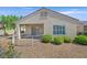 Back exterior featuring a covered patio, desert landscaping, and secure wrought iron fencing at 2548 Leighton Ave, Henderson, NV 89052