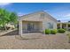 Back exterior featuring a covered patio, desert landscaping, and secure wrought iron fencing at 2548 Leighton Ave, Henderson, NV 89052
