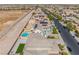 A bird's-eye view displays a backyard with a pool, patio, artificial turf, and a neighboring home at 2625 Cattrack Ave, North Las Vegas, NV 89081