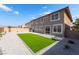 The home's backyard features artificial turf, a gravel border, and a gray exterior at 2625 Cattrack Ave, North Las Vegas, NV 89081