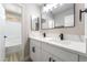 Bright bathroom featuring double sinks, white cabinets, black hardware and a large mirror at 2625 Cattrack Ave, North Las Vegas, NV 89081