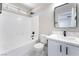 Bathroom featuring white tile, a bathtub, and vanity with black fixtures, plus a framed mirror at 2625 Cattrack Ave, North Las Vegas, NV 89081