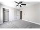 This bedroom boasts gray carpet, a ceiling fan, and a closet with an open door at 2625 Cattrack Ave, North Las Vegas, NV 89081