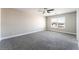 This bedroom has gray carpet, a ceiling fan, and a large window with bright, natural light at 2625 Cattrack Ave, North Las Vegas, NV 89081
