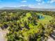 Scenic aerial view of a lush golf course with mature trees, sand traps, and a tranquil pond at 2625 Cattrack Ave, North Las Vegas, NV 89081