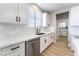 Kitchen featuring white cabinets, quartz countertops, a stainless steel dishwasher, and a sink at 2625 Cattrack Ave, North Las Vegas, NV 89081