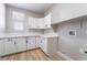 Bright laundry room featuring white cabinetry, quartz countertops, and wood-look flooring at 2625 Cattrack Ave, North Las Vegas, NV 89081