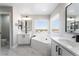 Bright main bathroom featuring a soaker tub with modern fixtures and marble floors at 2625 Cattrack Ave, North Las Vegas, NV 89081