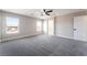 Brightly lit main bedroom featuring neutral carpet, ceiling fan and large windows at 2625 Cattrack Ave, North Las Vegas, NV 89081