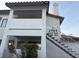 Exterior shot of a white two-story condo with stairs, a red tile roof and a small bush out front at 2701 Beaver Creek Ct # 201, Las Vegas, NV 89117