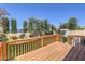 Wooden deck offers a relaxing outdoor space with lush landscaping and privacy hedges under clear blue skies at 2728 Aspen Wood Ave, Henderson, NV 89074