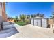 Backyard featuring a hot tub, shed, artificial turf, and tasteful landscaping for relaxation and storage at 2728 Aspen Wood Ave, Henderson, NV 89074