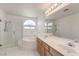 Bright bathroom featuring a glass-enclosed shower, soaking tub, double vanity, and marble floors at 2728 Aspen Wood Ave, Henderson, NV 89074