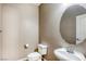 A bathroom featuring a toilet, sink, and a round mirror for a functional and modern look at 3905 Sweet Pine St # 102, Las Vegas, NV 89108