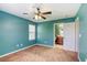 Bedroom with bright blue walls, carpet flooring, a window, and a ceiling fan, creating a vibrant and inviting space at 3905 Sweet Pine St # 102, Las Vegas, NV 89108