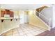 Open-concept kitchen and stairwell featuring a breakfast bar, abundant cabinets and tile flooring at 3905 Sweet Pine St # 102, Las Vegas, NV 89108