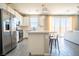 Bright, open kitchen featuring white cabinets, an island, and sliding glass doors to the backyard at 3922 Painted Lady Ave, Las Vegas, NV 89141