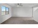 Spacious carpeted living area with bright white walls, fan and window at 4216 Golden Sol St, North Las Vegas, NV 89032