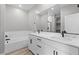 Modern bathroom with dual sinks, quartz counters, tub, and a large mirror at 4404 Cave Lake Ave, North Las Vegas, NV 89032