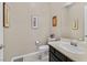 A well-lit half bath with a framed mirror and artwork adorning the walls at 444 Middlestone Ave, Henderson, NV 89011