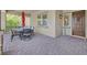 Inviting front porch with stone pavers, an outdoor dining set, and a decorative door at 444 Middlestone Ave, Henderson, NV 89011