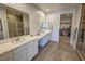 Well lit bathroom featuring double sinks, granite counter tops, walk in shower and closet at 4717 S Maddington Ct, Pahrump, NV 89061
