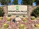 Mountain Falls entrance sign surrounded by desert landscaping with a stone base and barrel cactus at 4717 S Maddington Ct, Pahrump, NV 89061