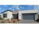Modern home featuring a low-maintenance front yard and two-car garage, in a neutral color palette at 4717 S Maddington Ct, Pahrump, NV 89061