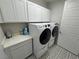 Bright laundry room features patterned tile floors, white cabinets, and a modern washer and dryer at 4717 S Maddington Ct, Pahrump, NV 89061