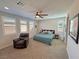 This main bedroom features carpet floors, chair, ceiling fan and natural light from the windows at 4717 S Maddington Ct, Pahrump, NV 89061