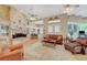 Spacious living room featuring a cozy fireplace, ceiling fans and large windows at 4936 Mountain Foliage Dr, Las Vegas, NV 89148