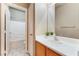 Bathroom with single sink, mirror and open door to a tiled shower and tub combo at 5031 Droubay Dr, Las Vegas, NV 89122