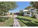Spacious backyard with green grass, patio, lush trees and shrubbery, and full landscaping at 55 Siddall Ave, Las Vegas, NV 89183