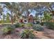 Landscaped yard surrounding a home with brick chimney and a variety of mature trees providing lots of shade at 55 Siddall Ave, Las Vegas, NV 89183