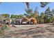 Residential home featuring a covered parking area, mature trees, and partially fenced yard at 55 Siddall Ave, Las Vegas, NV 89183