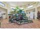 An indoor garden oasis sits in the middle of the home with brick floors and a light yellow walls at 55 Siddall Ave, Las Vegas, NV 89183
