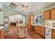 A cozy kitchen features wood cabinets, unique floors, and lots of sunlight from the surrounding windows at 55 Siddall Ave, Las Vegas, NV 89183