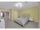 Spacious bedroom featuring bright yellow walls, soft carpet, and a large window with curtains at 5788 Robin Ridge Ave, Las Vegas, NV 89141